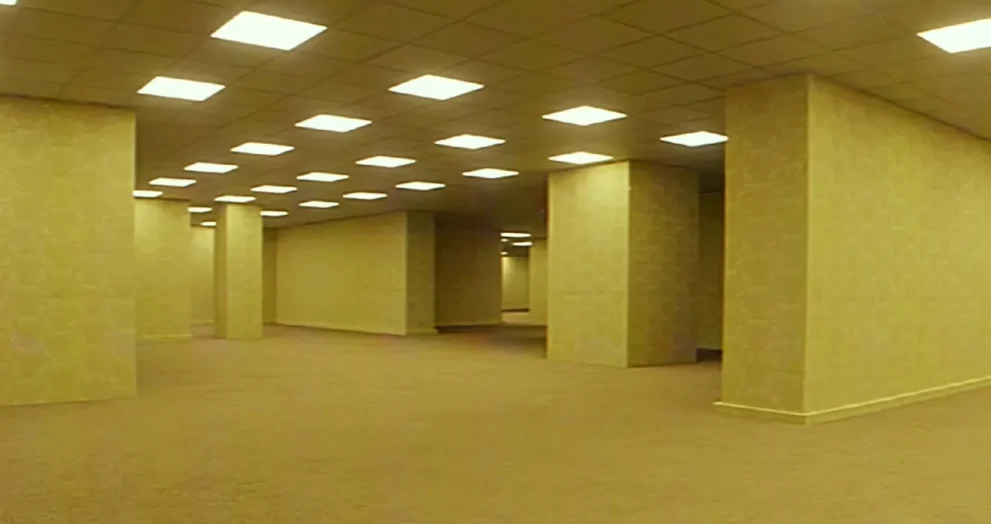 Empty open interior with beige walls, multiple square columns, and bright square ceiling lights.